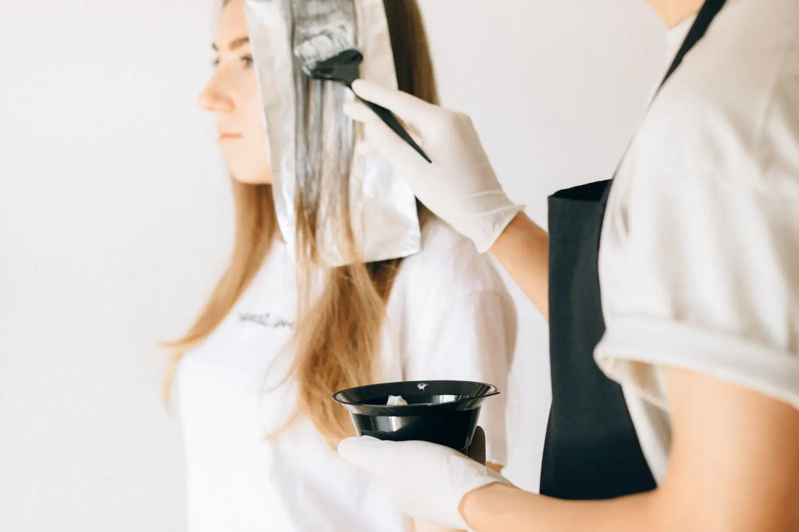 Stylist applying hair colour with a brush and foils