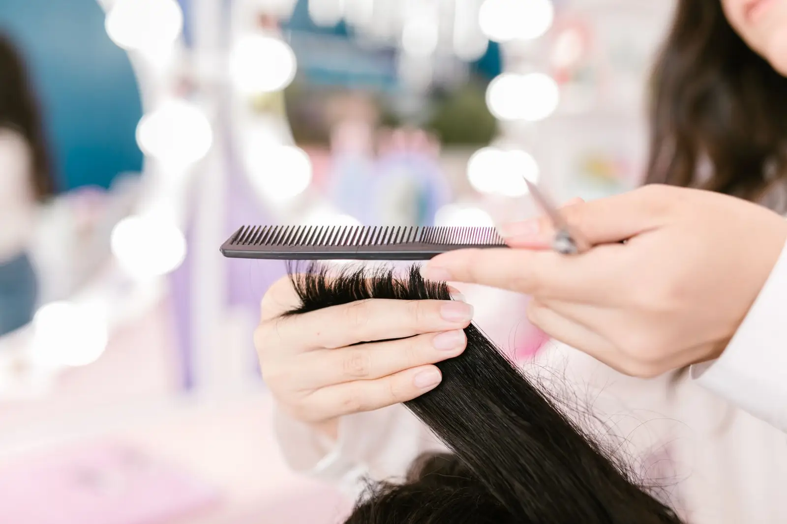 Hairdresser grooming hair with scissors and comb