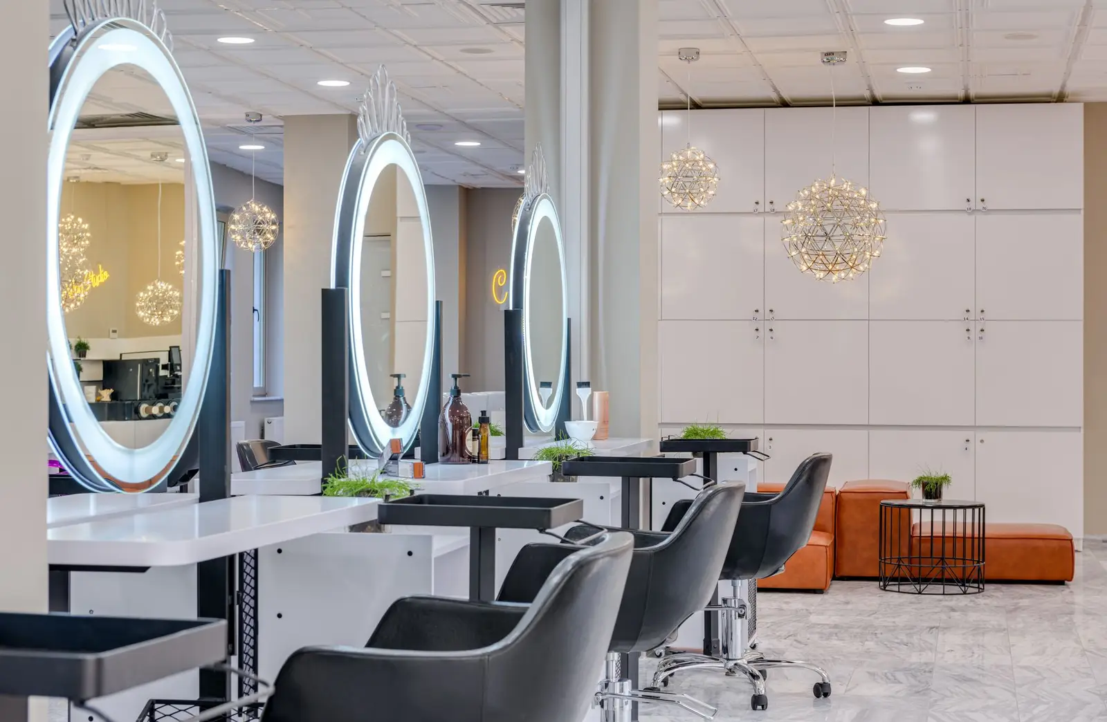 Salon with round mirrors and white styling stations